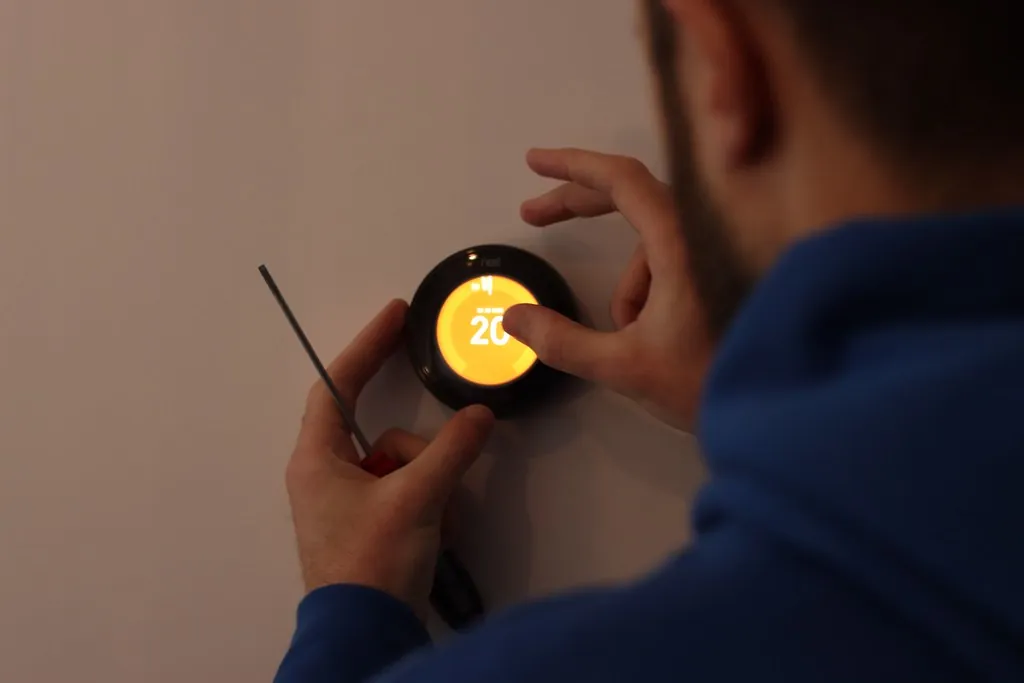Installation d'un thermostat connecté au mur pour la régulation du chauffage d'une maison intelligente