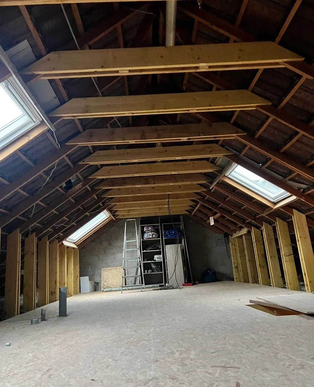 Combles d'une maison avant isolation, avec charpente apparente, à inspecter lors d'un achat immobilier